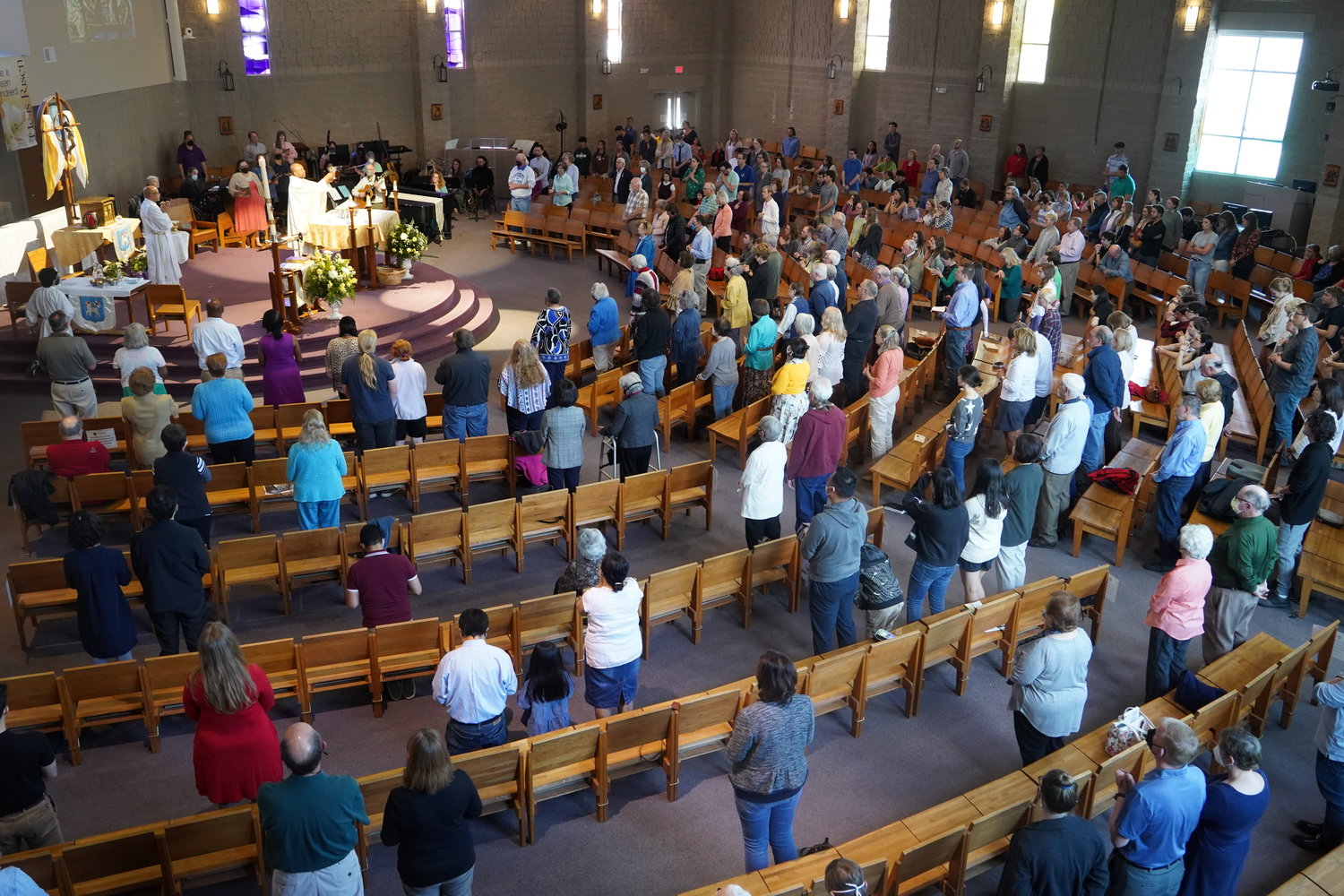 Parishioners and visitors gather around the altar for Mass in the St. Thomas More Newman Center Chapel in Columbia.
